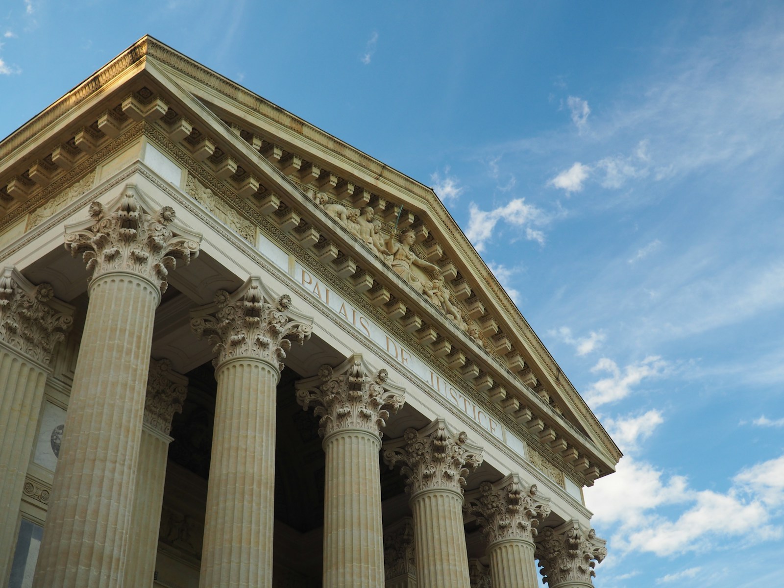 a tall building with columns and a sky background